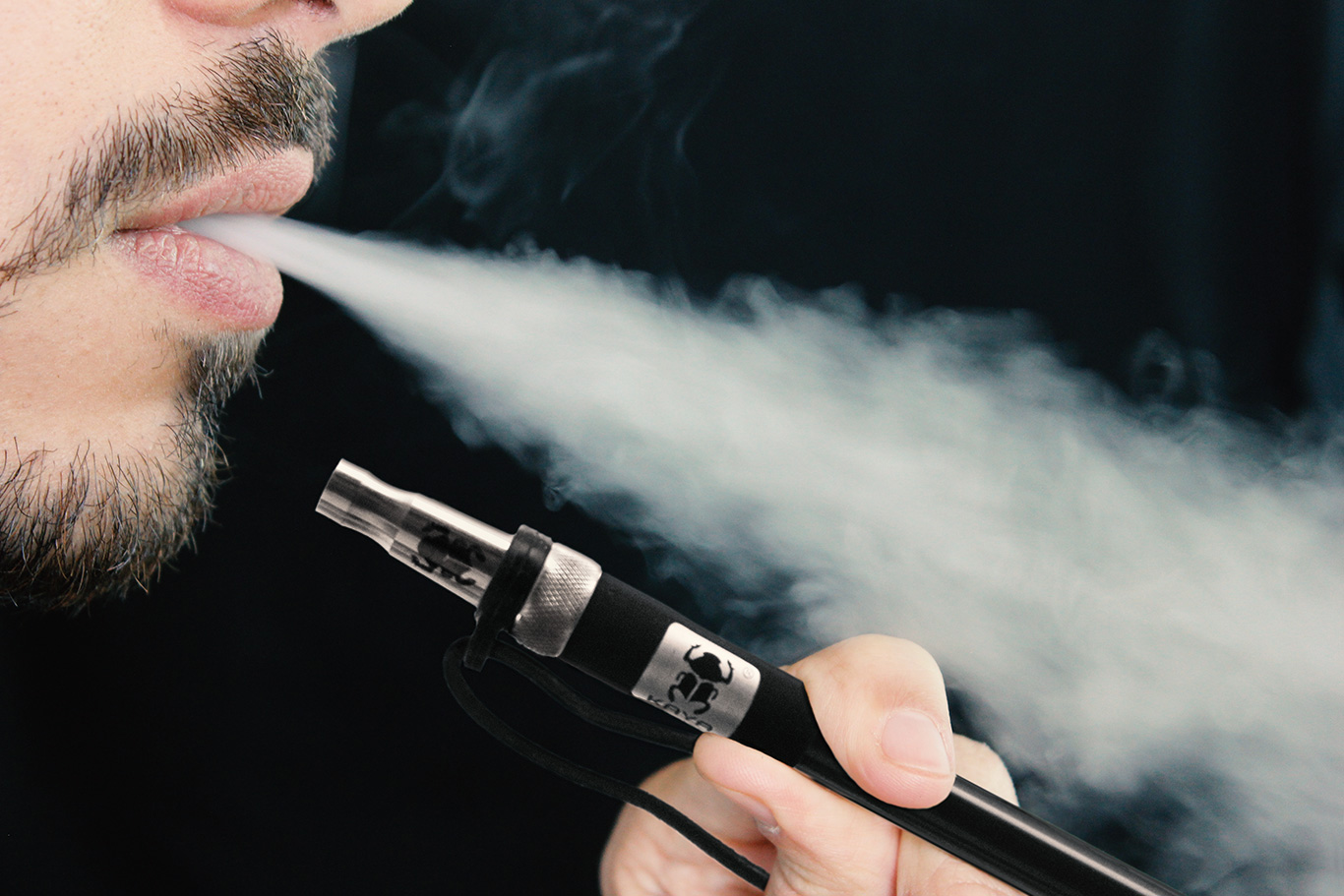 Mann raucht aus einer Kaya Edelstahl Mundstückspitze vor einem dunklen Hintergrund